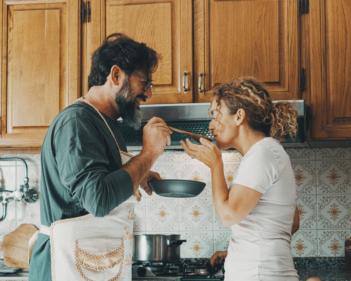 Man and woman tasting food in the kitchen